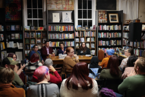 Community members fill a local bookstore in Newport for Queer Kentucky’s Queer Politics in the Bluegrass legislative preview panel, with panelists seated at the front discussing Kentucky’s 2026 legislative session.