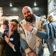 Attendees smile and pose at Lexington’s ‘Last WednesGays’ queer meetup inside a local bar, a monthly LGBTQIA+ networking event creating a safe, inclusive community space.