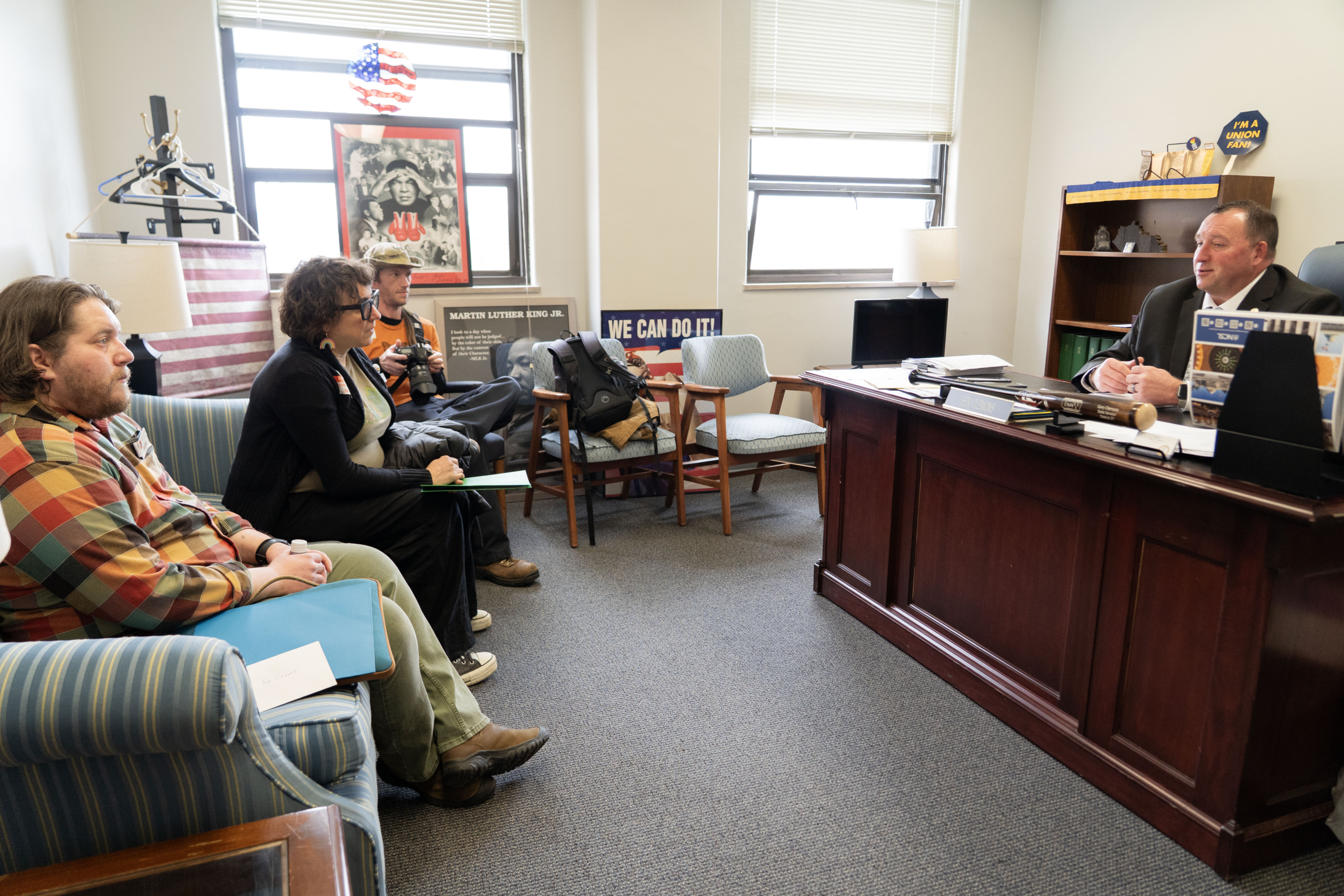 Advocates meet with a Kentucky lawmaker in his Frankfort office during the 2026 legislative session. A photographer documents the visit, which included a Martin Luther King Jr. tribute display and a "We Can Do It!" poster on the wall.
