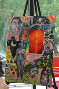 A bold, layered mixed media painting featuring expressive figures, a crucifix in red, cosmic and natural imagery, and the hand-lettered text "My suffering is not beautiful, but my survival is."