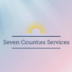 Seven Counties Services logo on a soft blue and pink gradient background, featuring a gold sunburst icon and navy blue serif text.