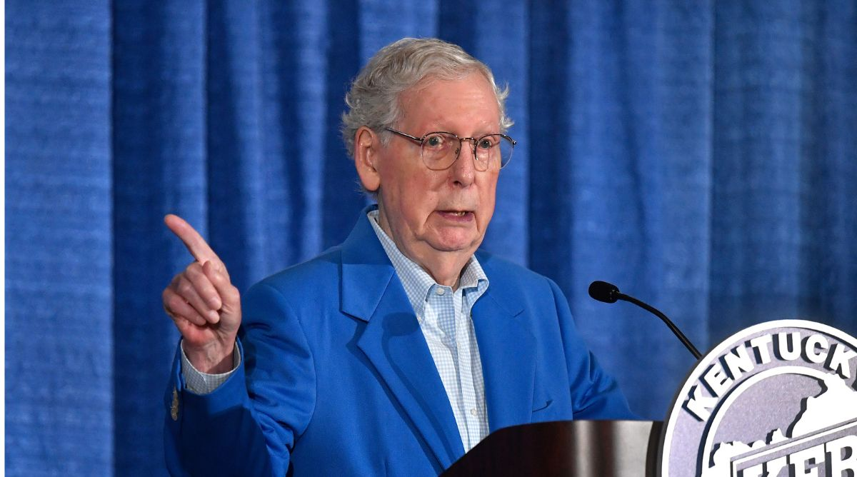Mitch McConnell behind a podium and pointing.