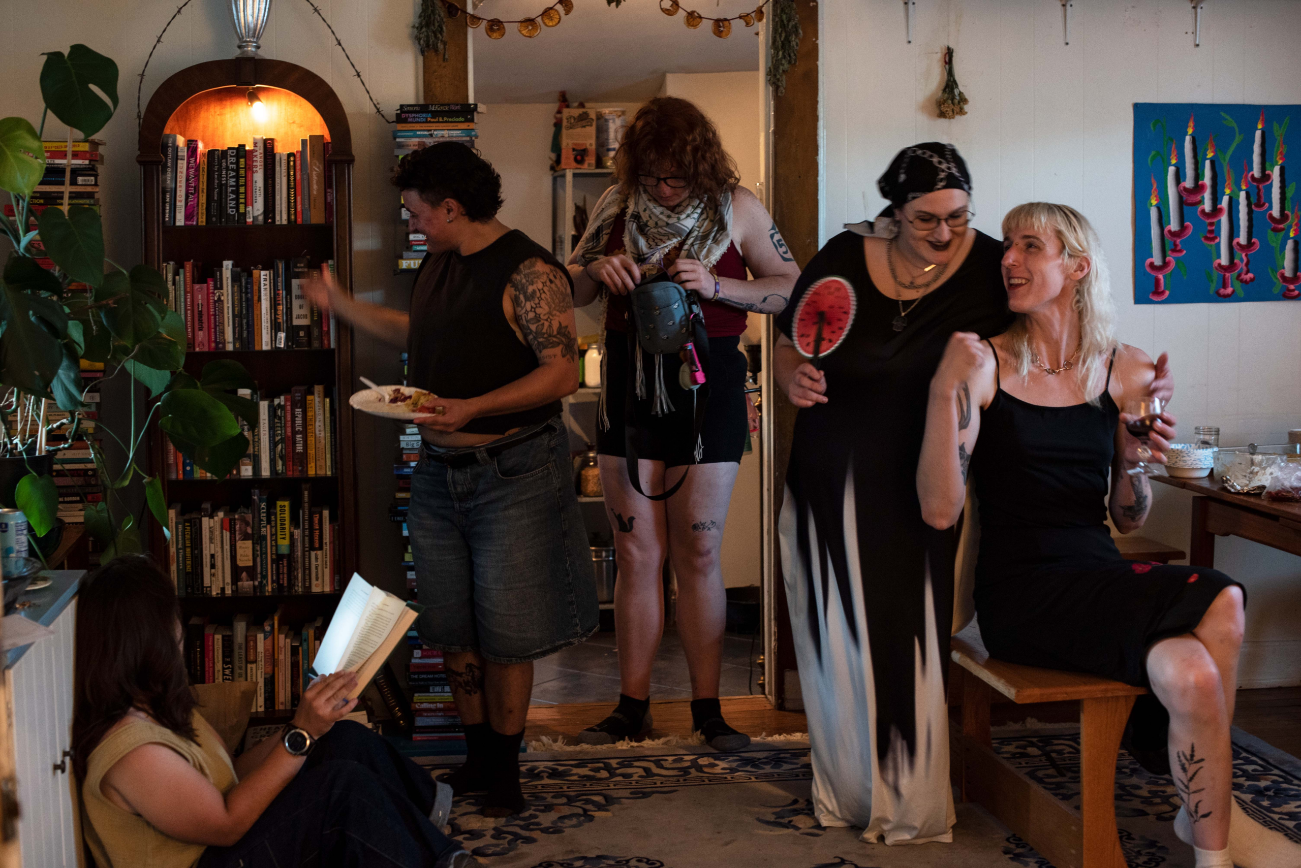 A group filled with smiles and love gathers in a home filled with books and decor.