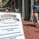A Whiskey Row Walking Tour sandwich board sign on a brick sidewalk in downtown Louisville as a man in a sun hat walks past.