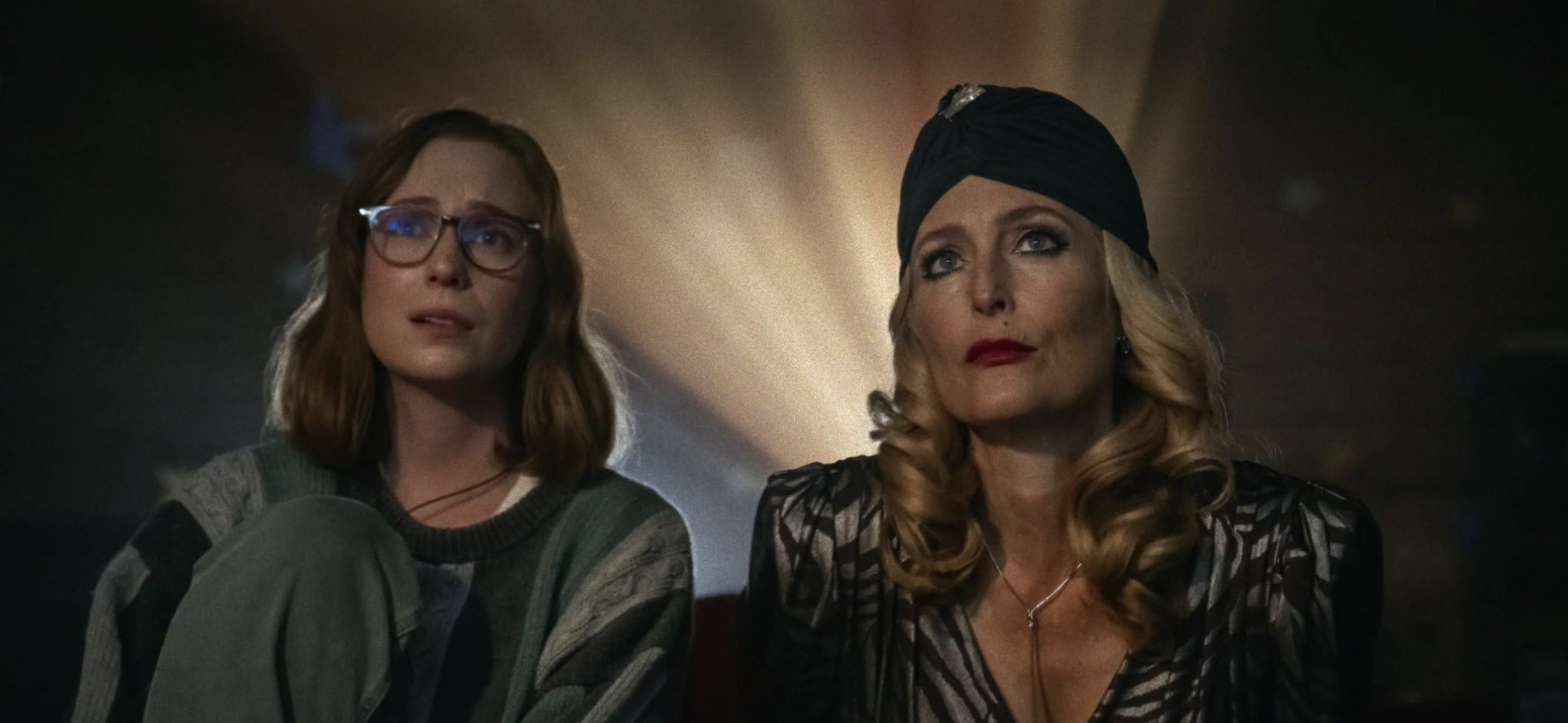 Kris and Billy sit side by side watching a film in Teenage Sex and Death at Camp Miasma (2026)